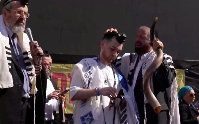 L’otage libéré Bar Kuperstein est enveloppé dans un châle de prière et porte les tefillin sur la place des Otages à Tel Aviv, le 31 octobre 2025. (Crédit : capture d’écran/Instagram)